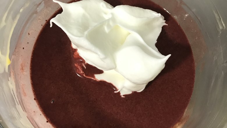 双色蛋糕卷,取其中一份的三分之一蛋白放入红曲粉蛋黄液中，用翻拌与切拌手法将两者混合均匀，再将面糊倒入剩余蛋白中拌匀。抹茶面糊也是同样的做法。
