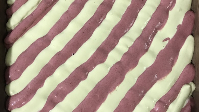 双色蛋糕卷,裱花袋剪小口，两种颜色交叉挤在烤盘里。
