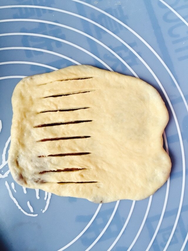 豆沙毛毛虫,擀成薄饼，用锋利的刀子割开，但不要两边都隔破