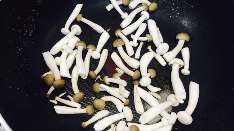 羽衣甘蓝藜麦帕玛火腿沙拉,蟹味菇和白玉菇去蒂放入锅中煸炒。
