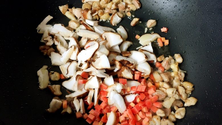 电饭煲+香菇鸡腿焖饭,放入香菇和胡萝卜翻炒均匀。