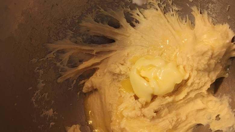 黃金椰蓉吐司,然後，將軟化后的黃油倒入料理桶中，攪打出土司必備的手套膜（耗時約15-20min）。