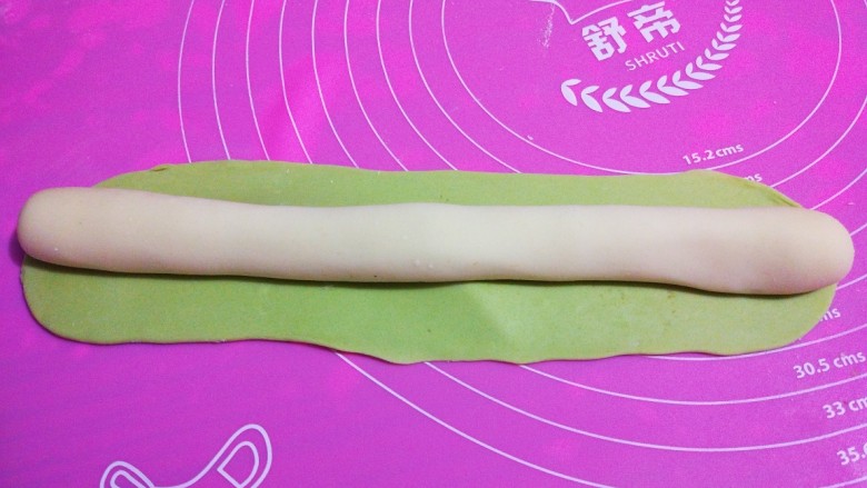 翡翠水饺,把白色面团放到擀好的绿色面团上。