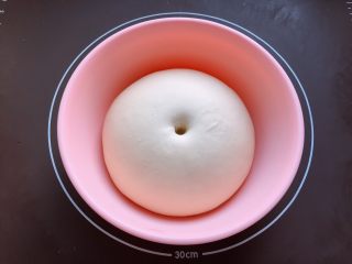 燕麦粒蜜豆小餐包,面团发酵至两倍大，手指沾粉在中间戳个洞，洞既不回缩又不塌陷即为发酵完成