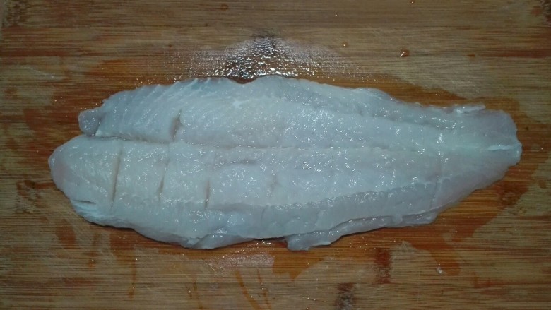 蒜苗酱香巴沙鱼柳,在巴沙鱼柳肉嫩的一面用刀横着划切数刀，不要切断