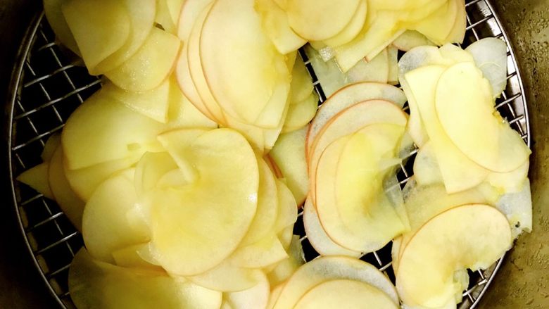 百变水果+苹果玫瑰花派,煮好的苹果片看出来放在盖帘上晾干水分备用。晾干的时候尽量要铺平整。