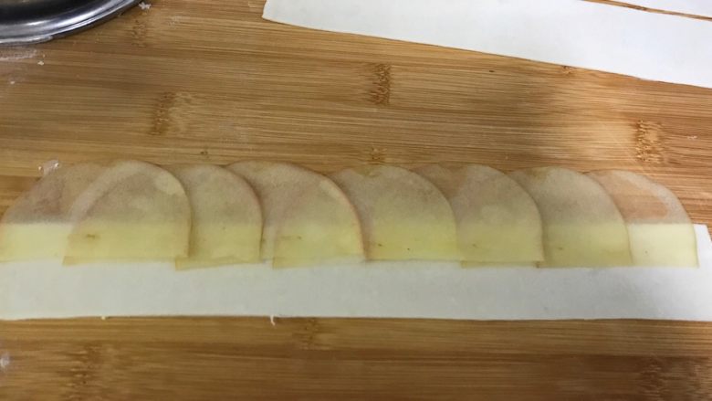 百变水果+苹果玫瑰花派,将苹果一片压着一片的放在面皮上端。我做的一个玫瑰卷大概是7片苹果片。