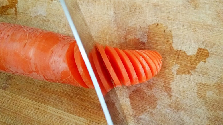 凉拌胡萝卜花,另一面45度切刀切，也不要切断，新手可以在萝卜两侧垫分别垫一根筷子，防止切断。
