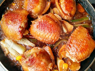 鸡翅包饭,两面都煎好后将腌制鸡翅的汤料倒入锅中和鸡翅一起煮至汤汁浓稠即可。