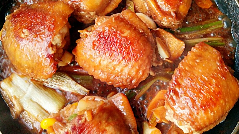 鸡翅包饭,两面都煎好后将腌制鸡翅的汤料倒入锅中和鸡翅一起煮至汤汁浓稠即可。