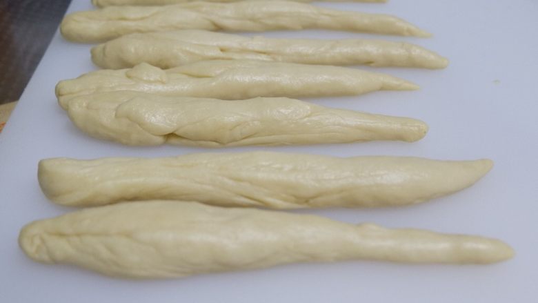 超级柔软的牛角面包,搓成胡萝卜形状，盖上保鲜膜松弛15分钟。






