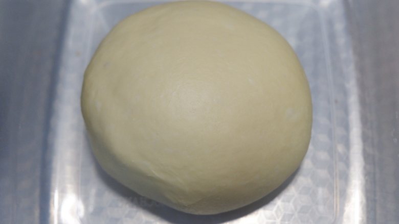 超级柔软的牛角面包,揉好的面团滚圆，放入容器盖上保鲜膜，进行一次发酵。