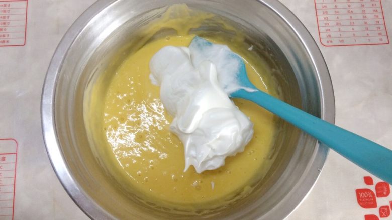 杯子蛋糕,把三分之一打发好的蛋白刮到蛋黄糊中，用刮刀翻拌均匀。
