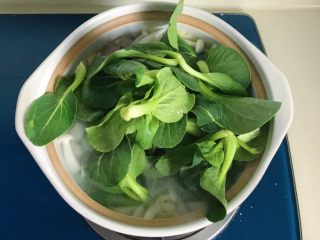 冬日暖汤の腊味三鲜砂锅,放入小青菜用勺子或筷子翻拌一下