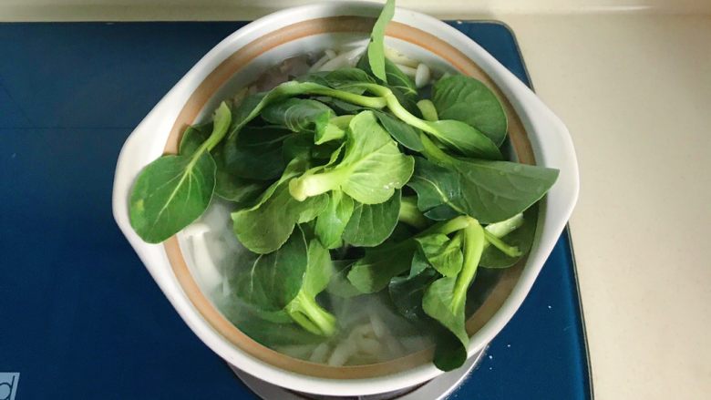 冬日暖汤の腊味三鲜砂锅,放入小青菜用勺子或筷子翻拌一下
