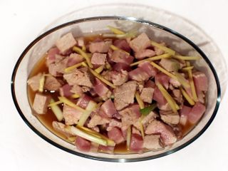 秘制肉松,切好的猪肉块放盆中，倒入料酒30毫升，加入葱段姜丝腌制半小时。