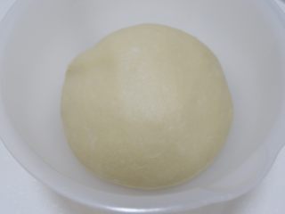 四叶草豆沙面包,揉好的面团滚圆，放入容器盖上保鲜膜。25-28温度下发酵至2-2.5倍大