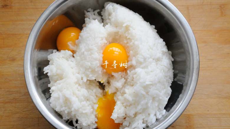 黄金蛋炒饭 完美金包银 剩米饭最Bigger的处理方法,把蛋黄打入到盛有米饭的容器中。
