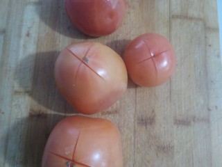 美味疙瘩汤,西红柿在顶上划一个十字，用开水烫一下去皮。