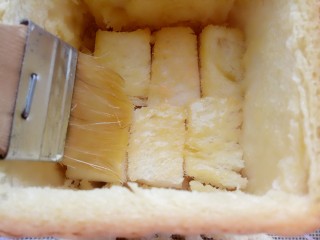 鲜虾厚多士,用刷子粘黄油蜂蜜液把吐司的内壁刷一遍，摆上一层切好的吐司块，再刷一层黄油蜂蜜液。
