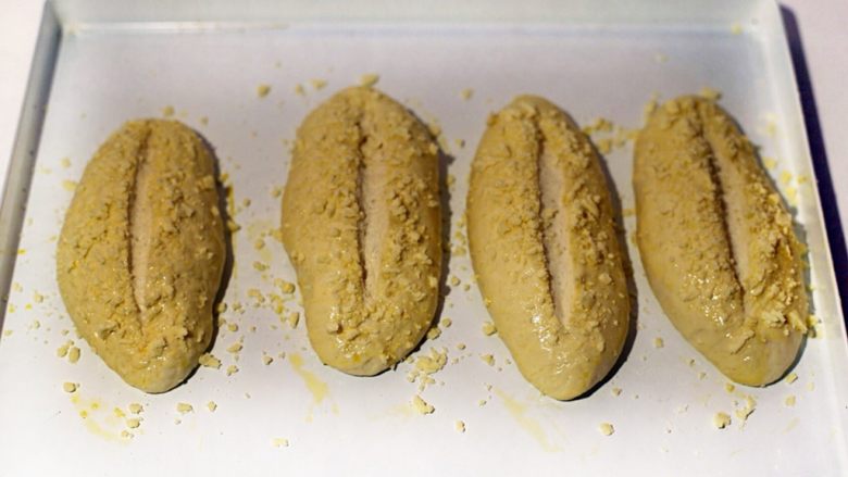 法国大蒜面包,松弛后的面团整形橄榄状，醒发箱36度湿度70%发酵1小时后取出，刷蛋液撒酥粒后中间割一刀。
