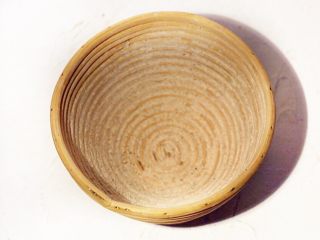 黑麦葡萄干椰子油软欧,在圆形发酵篮中撒些面粉，尽量将面粉填满发酵篮的凹线处，好脱模。