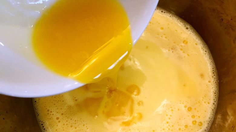 奶油千层蛋糕,将融化的黄油倒入蛋液中，搅拌均匀
