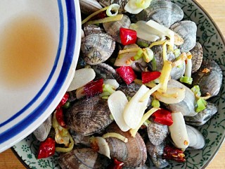 酒蒸蛤蜊――快手复刻美味,将2勺米酒和半勺味极鲜酱油混合均匀后淋在蛤蜊上。