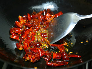 麻辣鲜香小鱿鱼,热油，辣椒和花椒先下锅煸出香味。