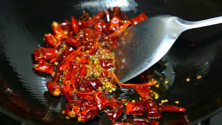 麻辣鲜香小鱿鱼,热油，辣椒和花椒先下锅煸出香味。