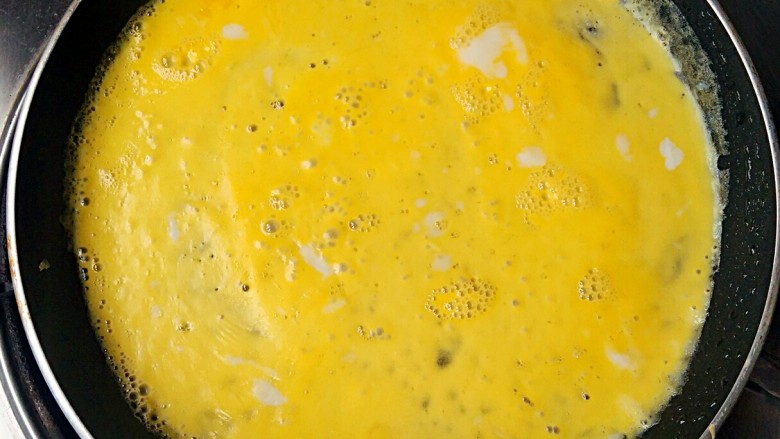 向日葵蛋包饭,轻轻晃动锅子，煎成一张蛋皮。