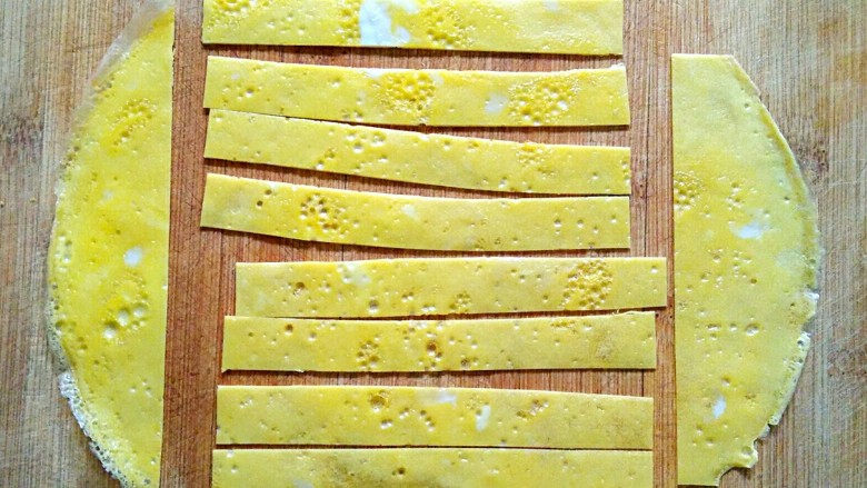 向日葵蛋包饭,将蛋皮切去四边，中间切成长条，切下来的边剪成三角形。
