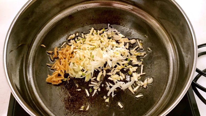 芽菜腊肉,锅里加入大豆色拉油，烧热后加入大蒜，葱姜丝，炒出香味