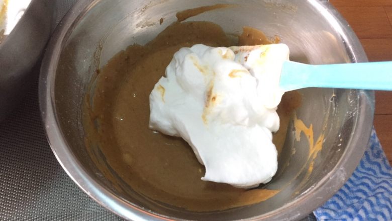 咖啡蛋糕杯,取1/3蛋白霜拌入蛋黄糊中，翻拌均匀