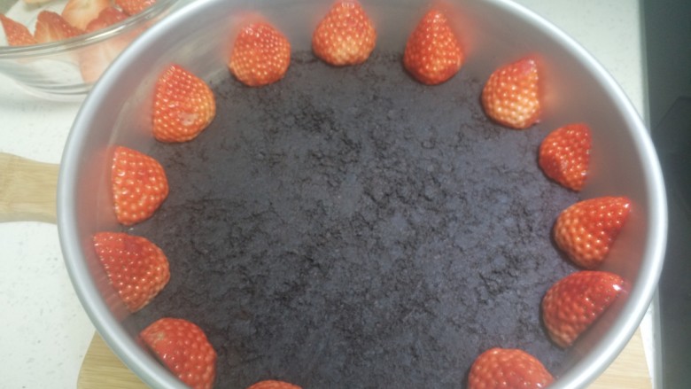 草莓冻芝士蛋糕,奥利奥饼底变硬后将草莓贴着模具放好