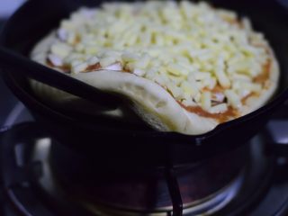 铸铁锅基础披萨,七八分钟后，如果饼底可以轻松揭起来，并且看得到略略发黄，就可以关火。