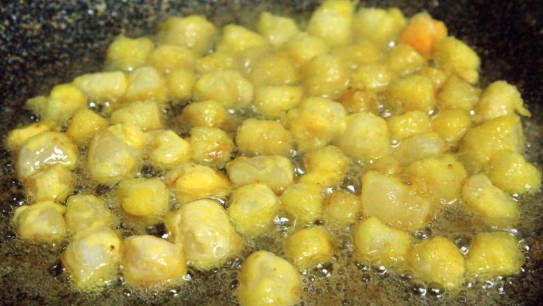 咸蛋黄扇贝丁,下入裹好淀粉的扇贝丁炸至金黄色，捞出沥油！（扇贝丁很容易熟）