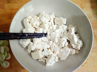 鸡刨豆腐,用筷子将豆腐块打成散块。