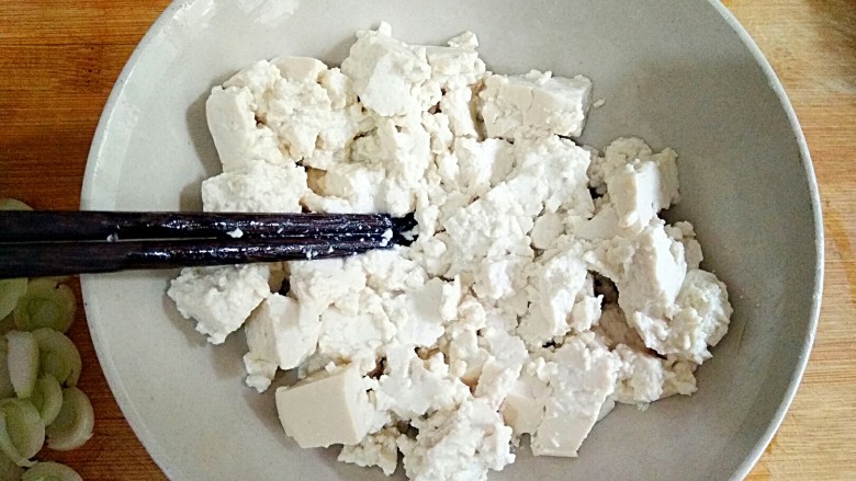 鸡刨豆腐,用筷子将豆腐块打成散块。