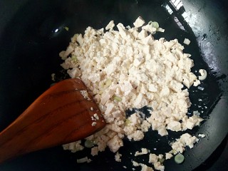 鸡刨豆腐,将豆腐入锅中，翻炒到水份蒸发。