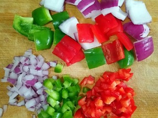 咖喱鱼蛋,青红辣椒洗净、去籽，切成小方块;洋葱洗净，一部分切成和辣椒大小的方块，一部分切碎粒。