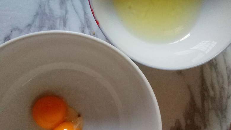 草莓纸杯蛋糕,蛋黄和蛋白分离在两个干净的料理盆中