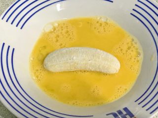 百变水果+酥炸香蕉,香蕉在蛋液里滚一下，全身粘匀蛋液。