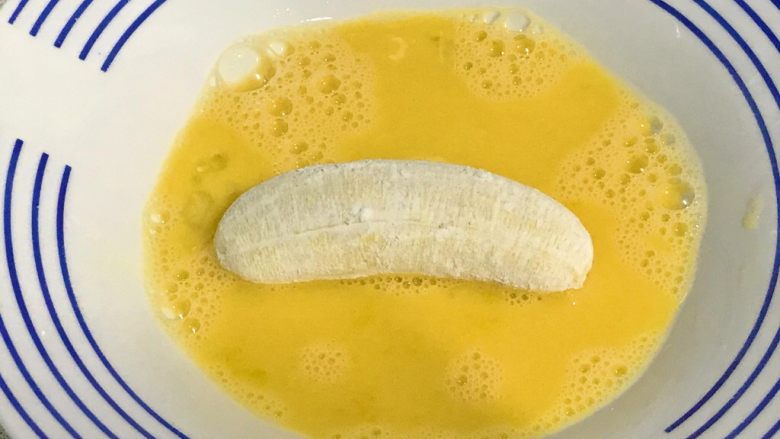 百变水果+酥炸香蕉,香蕉在蛋液里滚一下，全身粘匀蛋液。