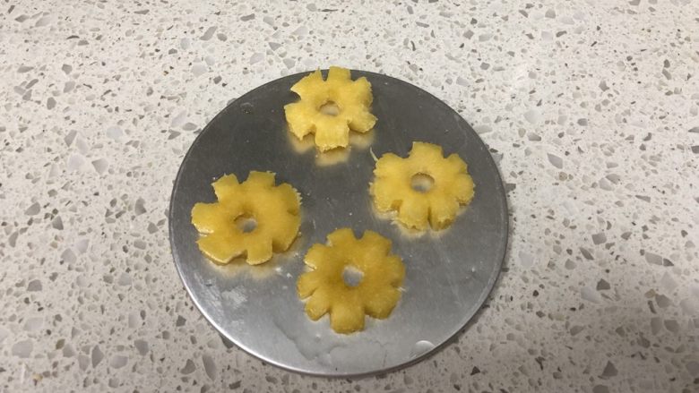 百香果慕斯蛋糕,【镜面制作】菠萝切片，用圆的模具按压出原片，用小刀雕刻出小花造型