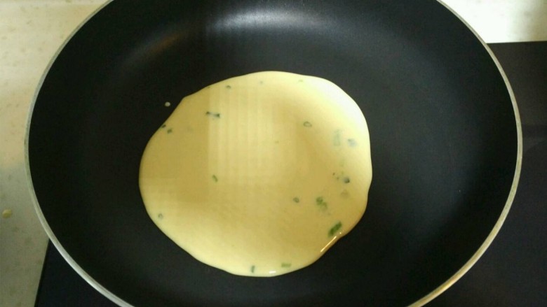 葱香牛奶鸡蛋饼,平底锅抹上一层薄油，烧热后转小火，舀上一勺蛋糊倒入。