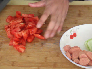 家常炒面,火腿肠也切片，西红柿切丁装盘备用。