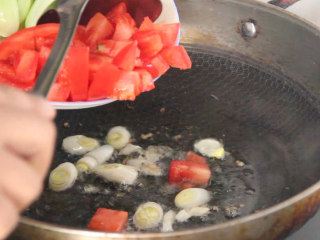 家常炒面,锅烧油，先下入葱炒香后再下入西红柿丁翻炒。
