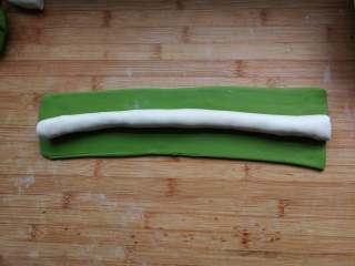 翡翠烧麦,白色面团搓成圆的长条，绿色面团擀成长方形面皮，长度与白色长条相同。