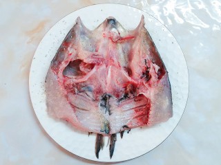 双椒焗鱼头,把鱼背翻过去，在鱼肚子这面也均匀的撒上盐和胡椒粉！腌制十五分钟左右！